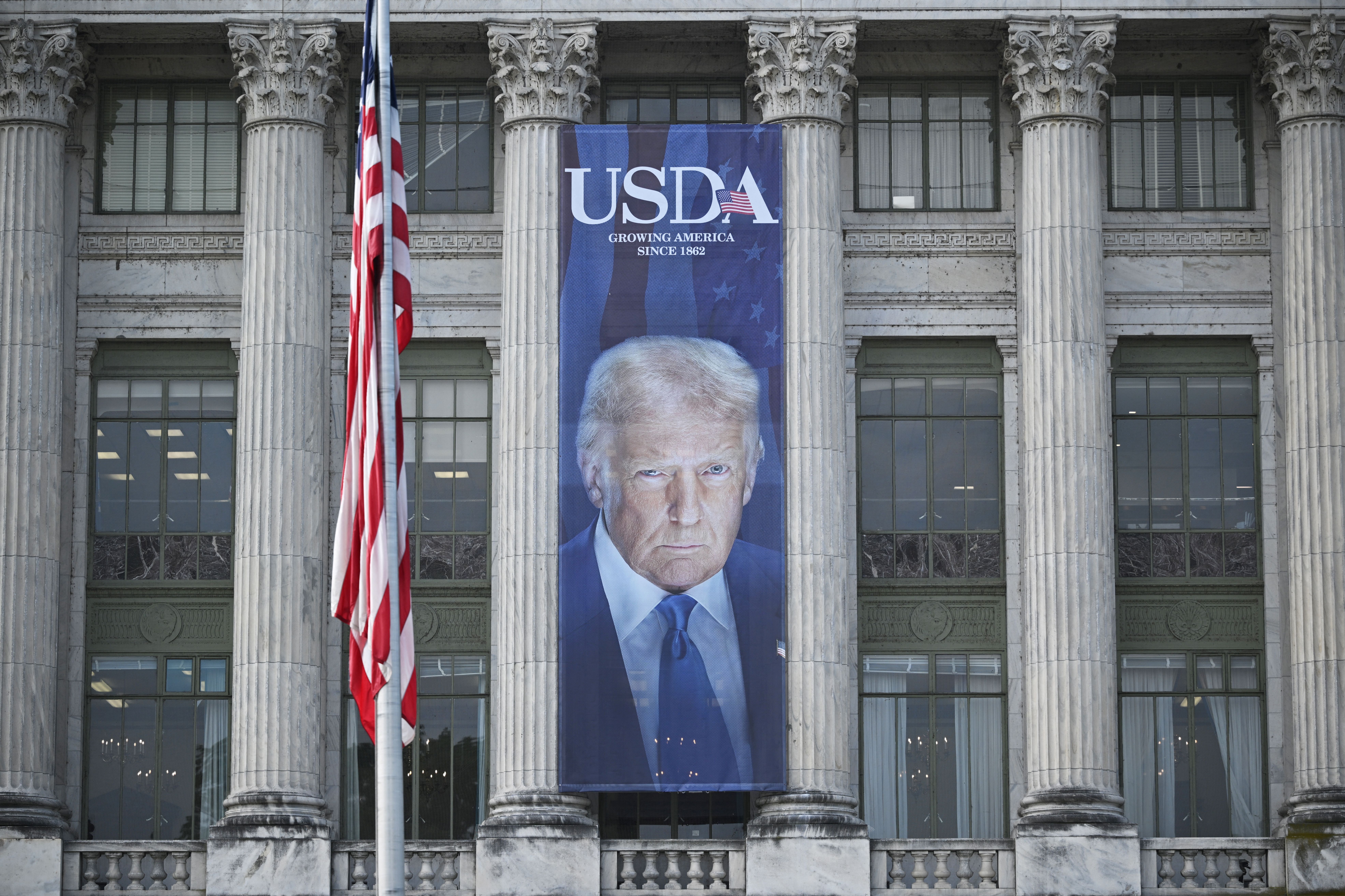 A banner showing an image of President Trump hangs on the side of the U.S. Department of Agriculture building in Washington, DC. The department wants states to turn over records about tens of millions of people who have received federally-funded nutrition assistance by July 30.