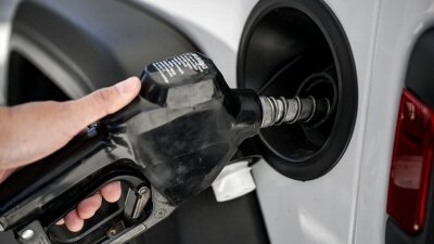 A man uses a gas pump at a Shell gas station in Houston.
