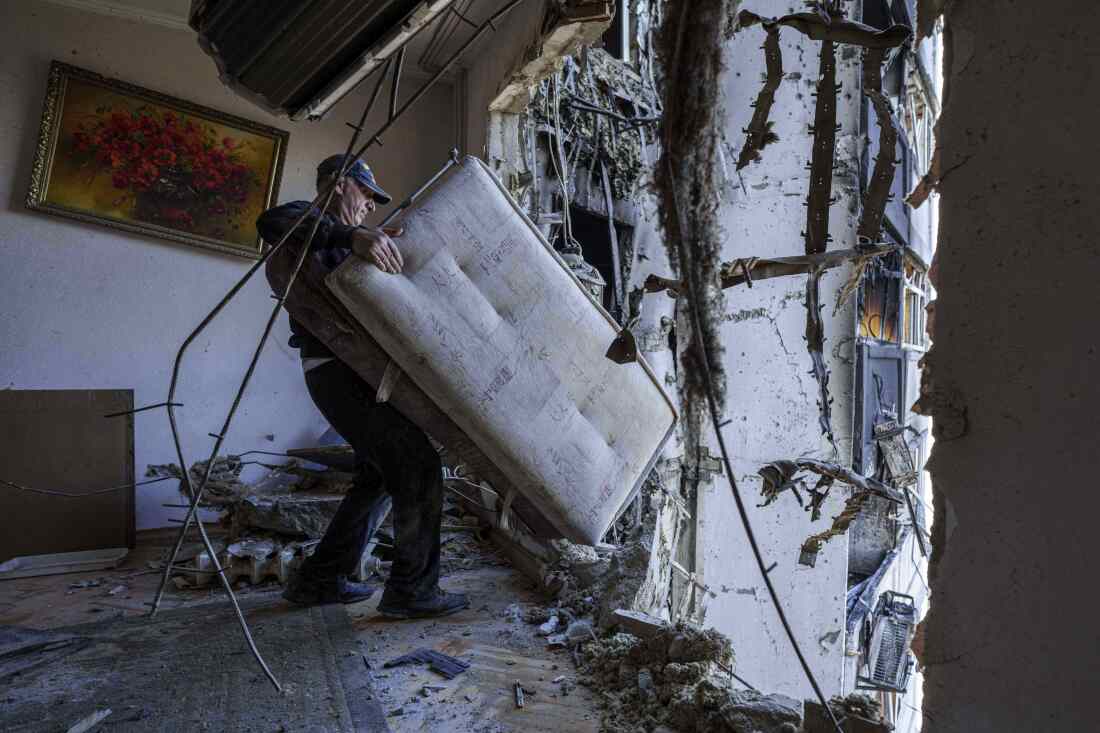 A man carries a sofa at his apartment damaged by a Russian strike in Kyiv, Ukraine, on Thursday.