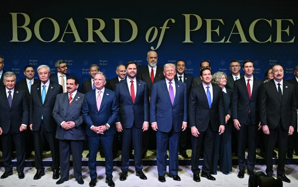 President Trump, flanked by Vice President JD Vance and Secretary of State Marco Rubio, joins leaders for a group photo during the inaugural meeting of the Board of Peace in Washington on Thursday. (AFP via Getty Images)