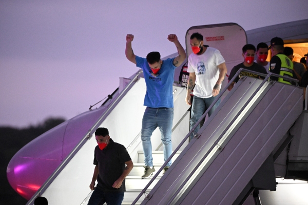 A Venezuelan migrant who was jailed in El Salvador gestures as he gets off a plane at Simon Bolívar International Airport in Maiquetía, Venezuela on Friday. El Salvador freed scores of Venezuelans deported from the United States to a notorious maximum security prison, the outcome of a highly coordinated prisoner swap between Caracas and Washington.