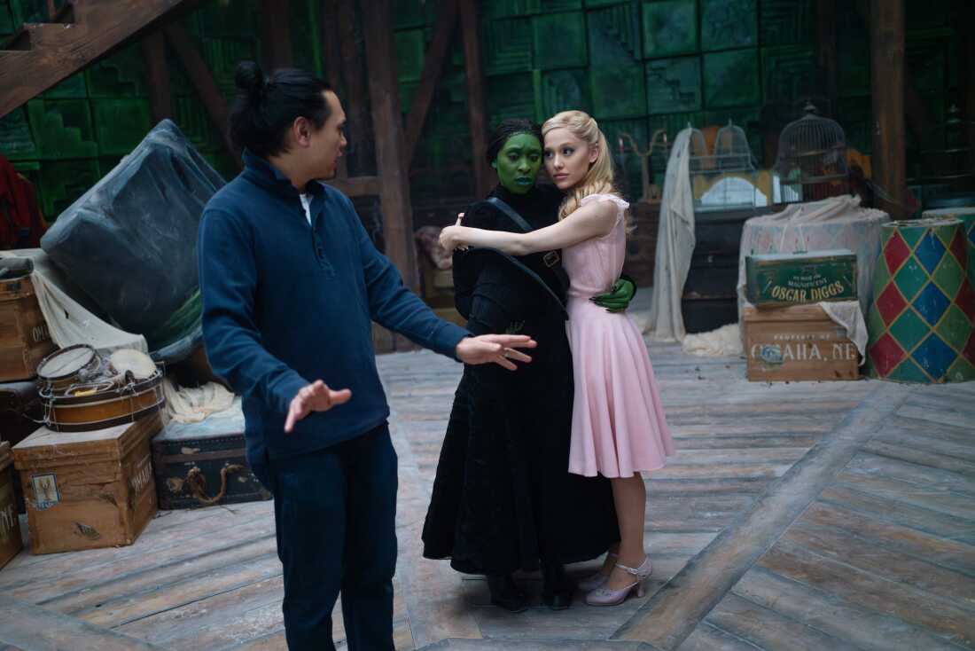 Jon M. Chu directs Cynthia Erivo and Ariana Grande on the set of Wicked.