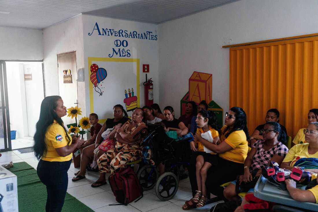 Alessandra Hora dos Santos (left) talks during a meeting with the mothers and children of the Association Familia de Anjos in Maceio, Alagoas, Brazil. December 20, 2024.