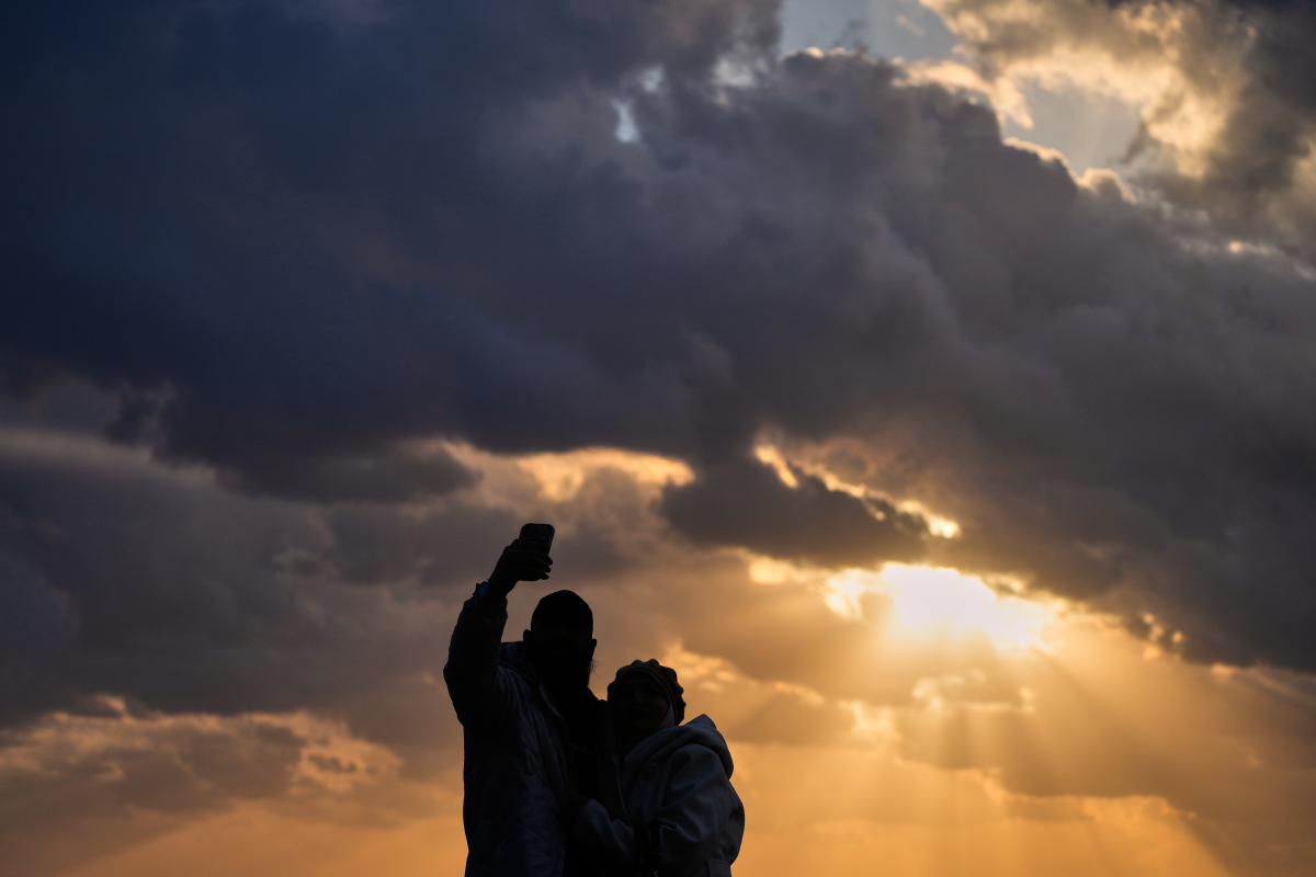 A couple takes a selfie as the last sunset of 2025 is seen over the Mediterranean Sea in Beirut, Lebanon, Wednesday, Dec. 31, 2025.