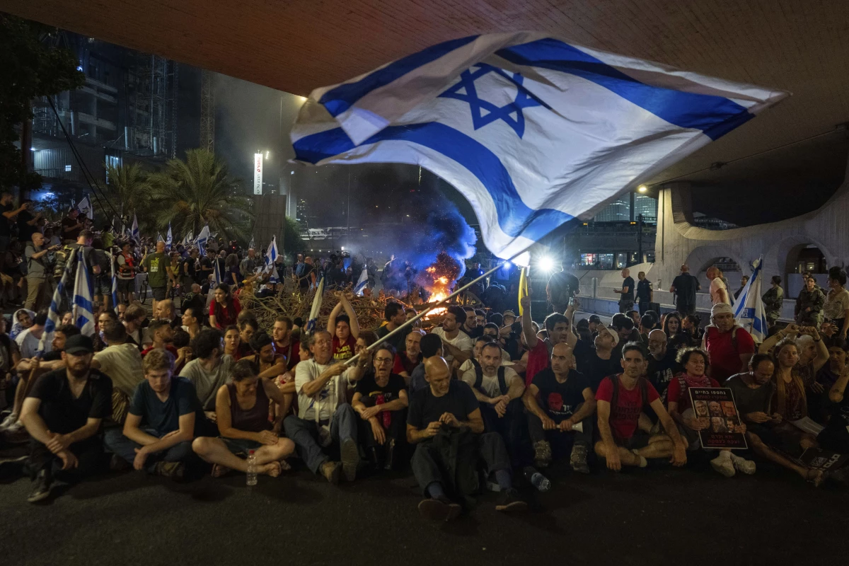 People block a road as they protest, calling for a deal for the immediate release of hostages held in the Gaza Strip by Hamas, in Tel Aviv, Israel, Sunday, Sept. 1, 2024.