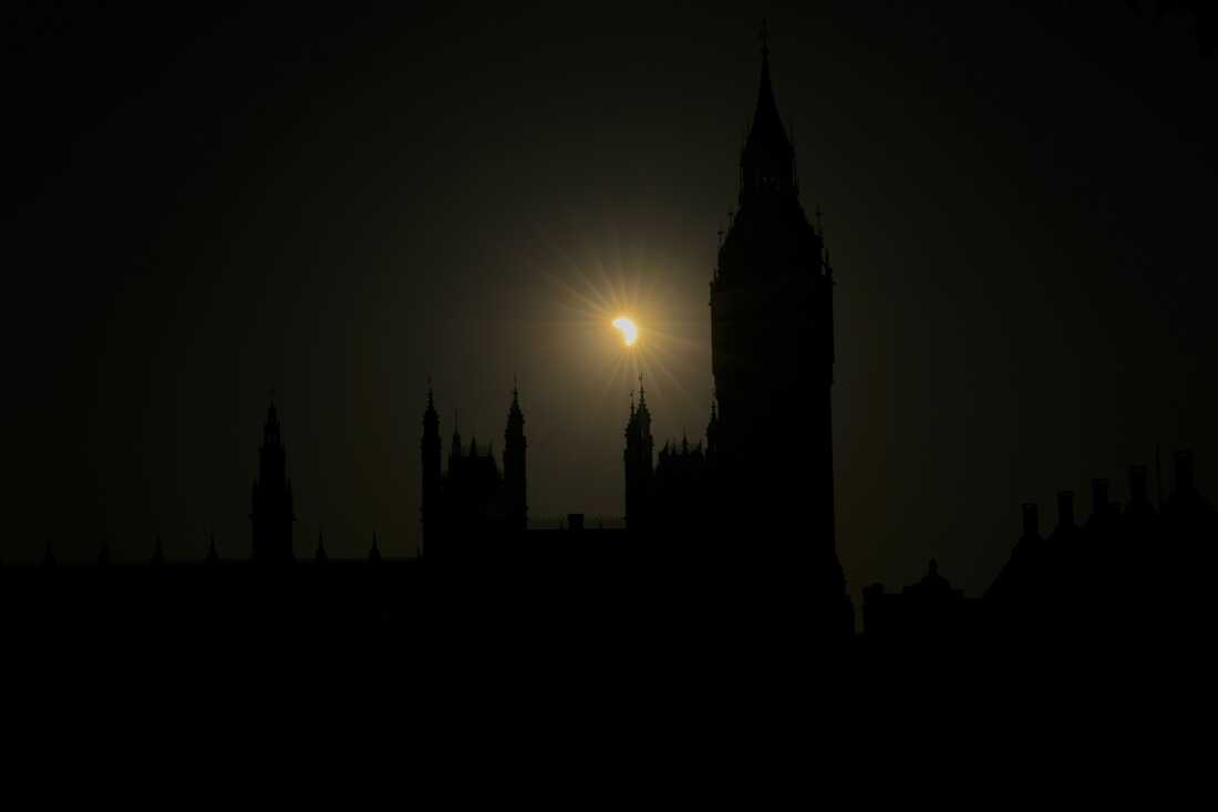 A partial solar eclipse is seen above the Houses of Parliament in London, Wednesday, Aug. 12, 2026.