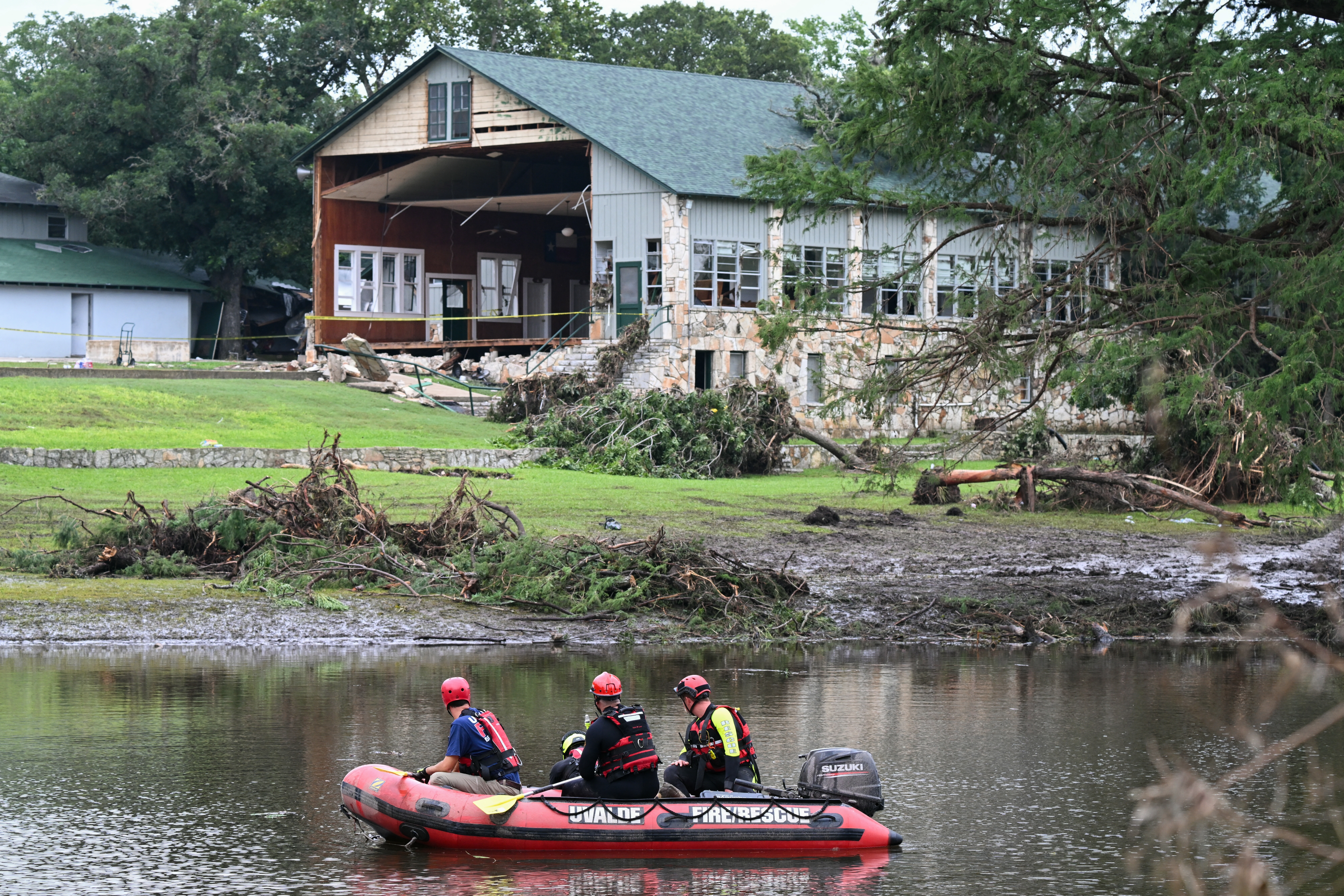 A search and rescue team looks for people along the Guadalupe River near a damaged building at Camp Mystic. Federal regulators repeatedly granted appeals to remove Camp Mystic