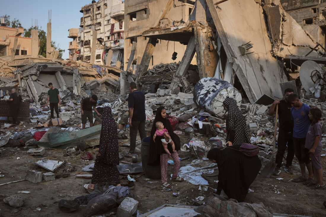 Palestinians salvage their belongings from the rubble of a building and tents destroyed in an Israeli airstrike in Gaza City, Thursday, July 30, 2026.