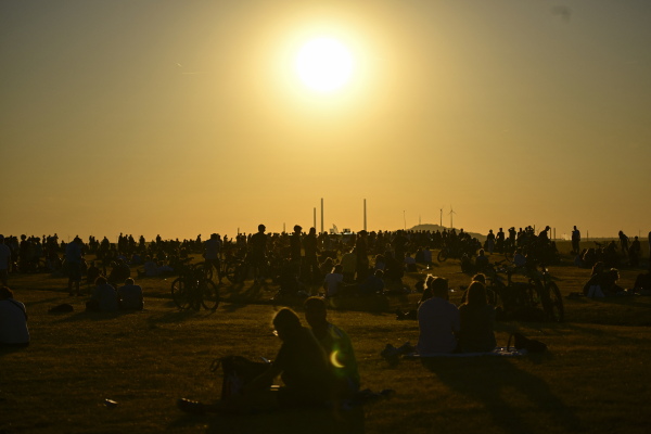 People look to the solar partial eclipse in the landscape park Halde Hoheward in Herten, western Germany.