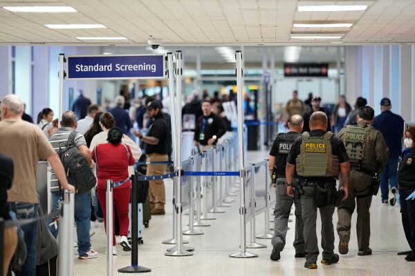 Federal immigration officers walk through a security checkpoint at George Bush Intercontinental Airport in Houston in March.