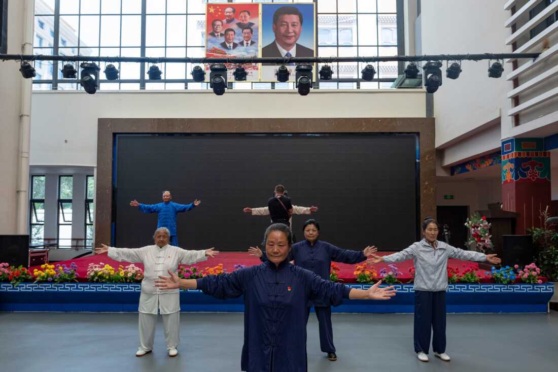 Elderly residents perform tai chi near the portrait of Chinese President Xi Jinping and other Chinese leaders at the Chengguan District Day Care Center for the Elderly in western China's Tibet autonomous region on July 20, 2026, as seen during a government-organized visit for foreign journalists.