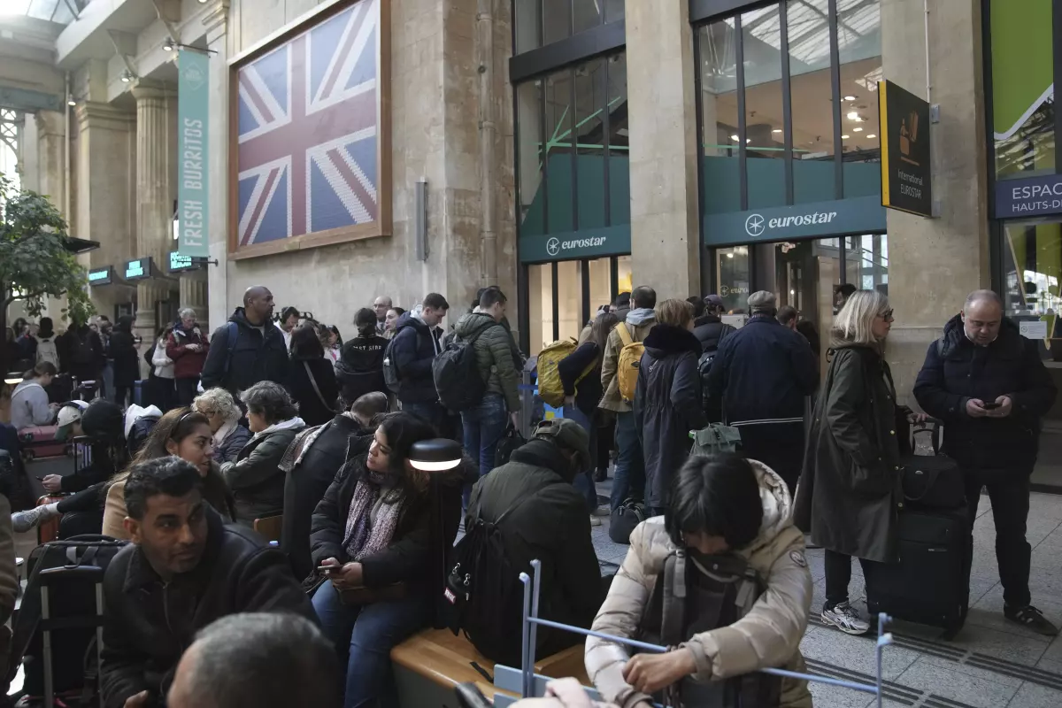 Travelers wait as Eurostar trains to London and all trains heading to northern France have been brought to a halt following the discovery of an unexploded bomb dating back to World War II near the tracks on Friday, March 7, 2025, at the Gare du Nord station in Paris.