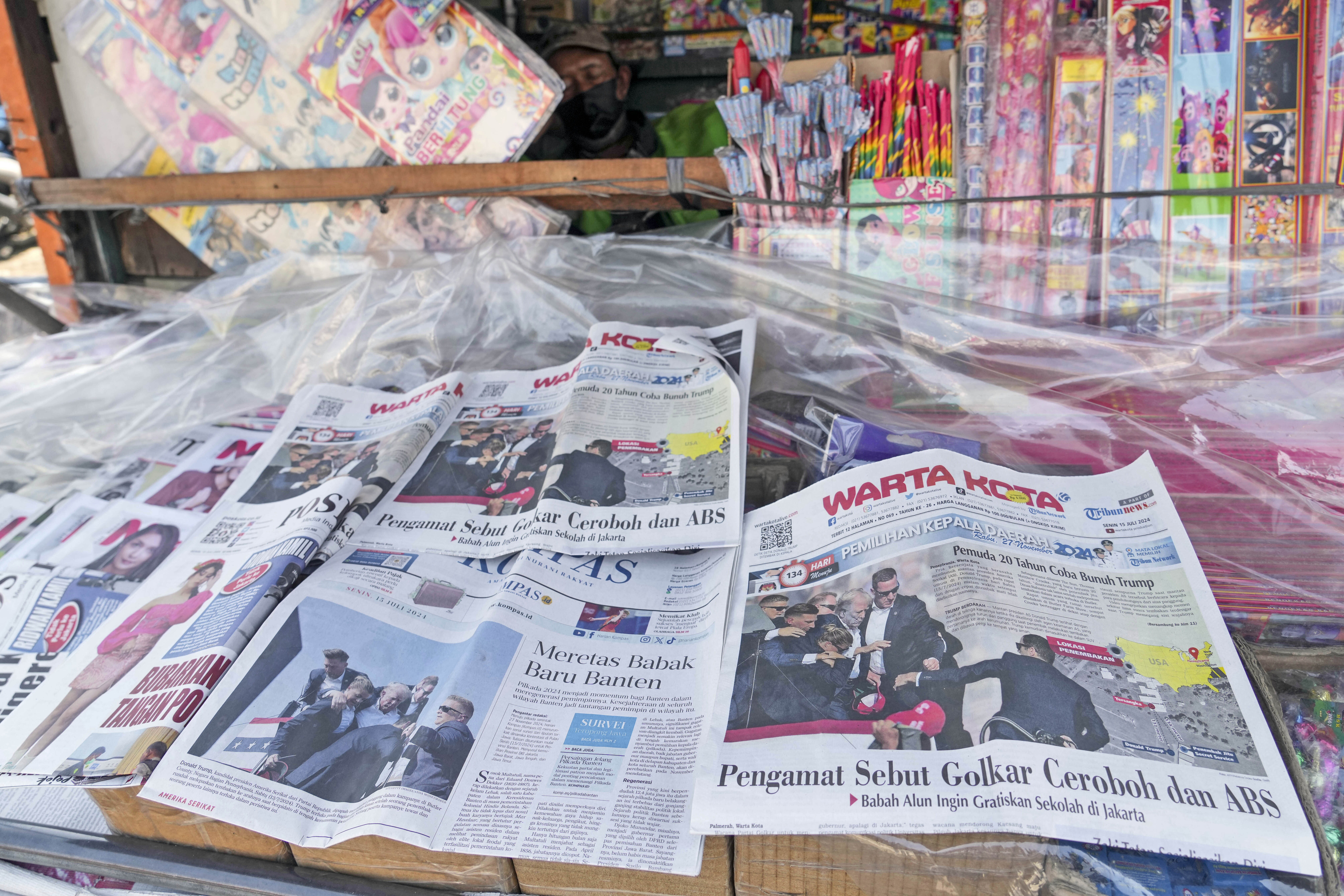 A vendor dozes off as newspapers are seen carrying front-page stories of Republican presidential candidate and former President Donald Trump, at a newsstand in Jakarta, Indonesia, Monday. (AP)