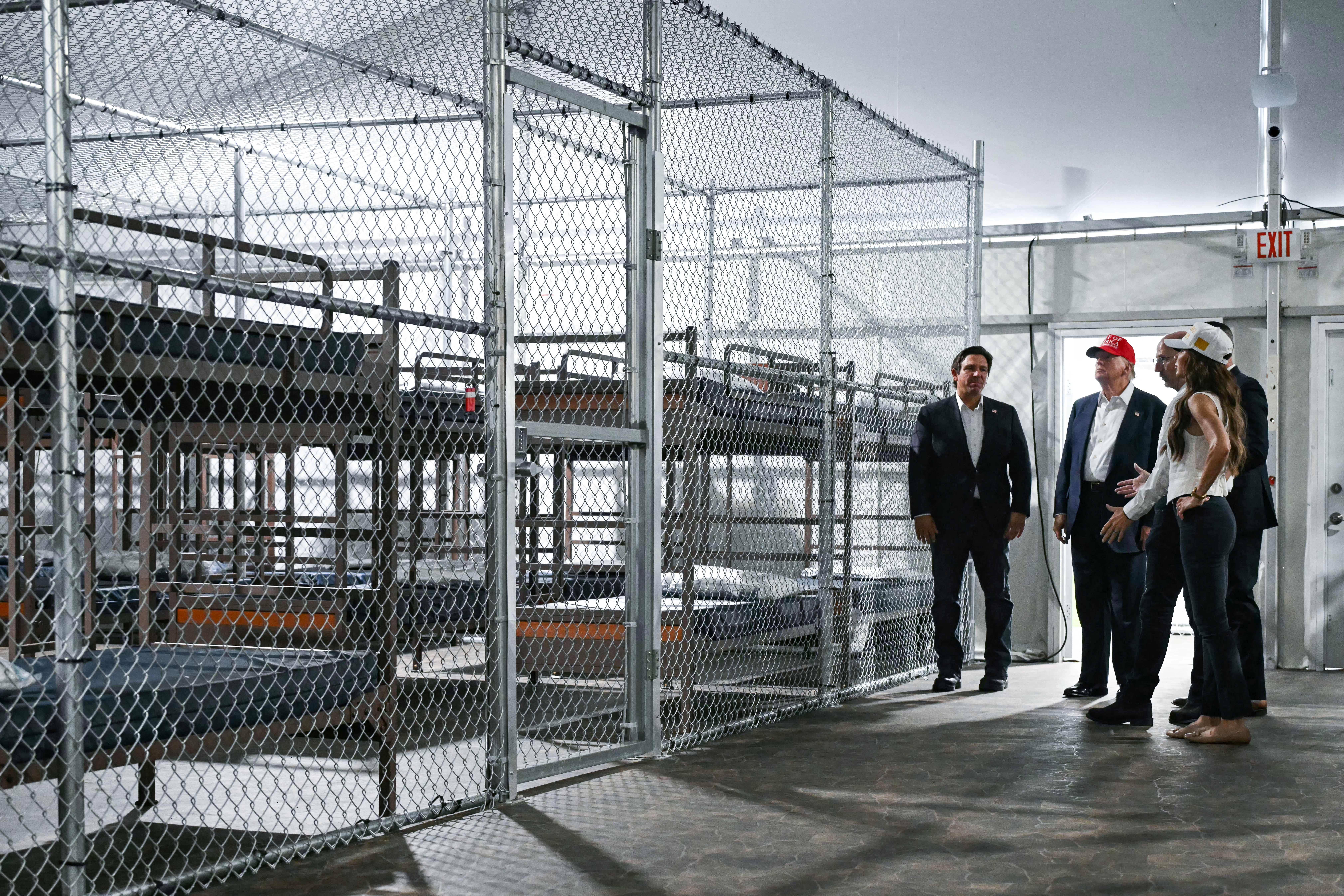 President Donald Trump, along with officials including Florida Gov. Ron DeSantis and Homeland Security Secretary Kristi Noem, tour the new migrant detention facility at the Dade-Collier Training and Transition Airport in Ochopee, Fla., on Tuesday.