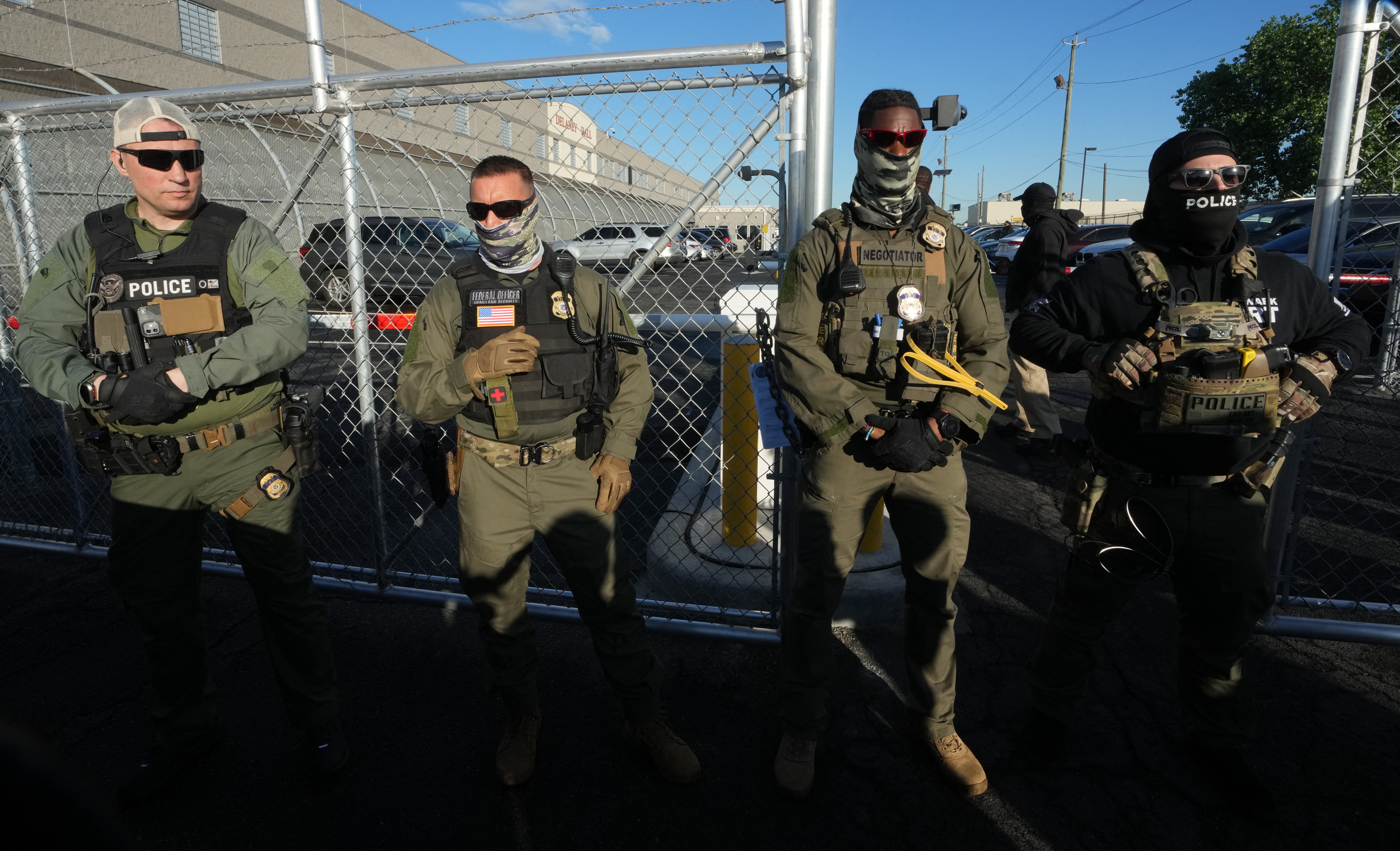Immigration and Customs Enforcement agents stand near a gate at Delaney Hall, an immigrant detention center in Newark, N.J., in May 2025.