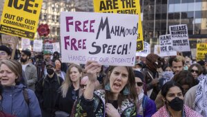 In this photo, protesters attending a demonstration hold signs declaring support for Mahmoud Khalil.
