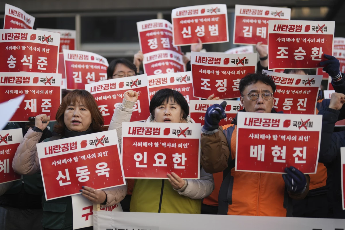 Members of the Korean Confederation of Trade Unions shout slogans as they hold signs carrying the names of the ruling party's lawmakers who didn't vote at the impeachment motion last week, during a rally in front of the ruling People Power Party's head office in Seoul, South Korea on Monday.
