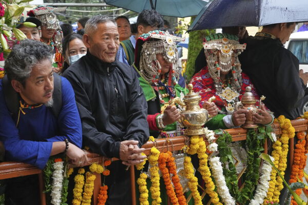 Devotees in their traditional dress wait for the arrival of Tibetan spiritual leader the Dalai Lama to attend an event celebrating his 90th birthday in Dharamshala, India, Sunday.