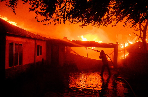 A firefighter douses flames during the Eaton fire in Pasadena, Calif., on Wednesday.