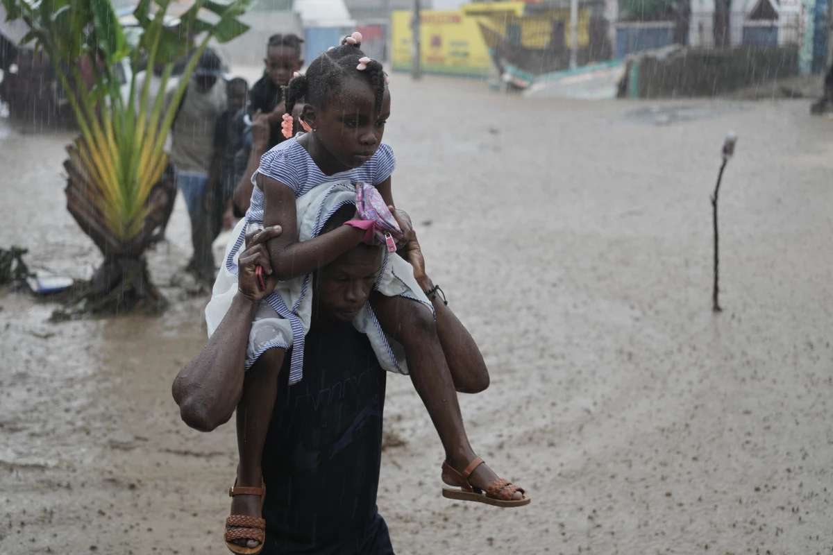 Residents wade through a flooded street in the aftermath of Hurricane Melissa in Petit-Goave, Haiti, on Thursday.