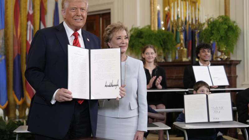 President Donald Trump holds up a signed executive order alongside Secretary of Education Linda McMahon in the East Room of the White House in Washington, Thursday, March 20.