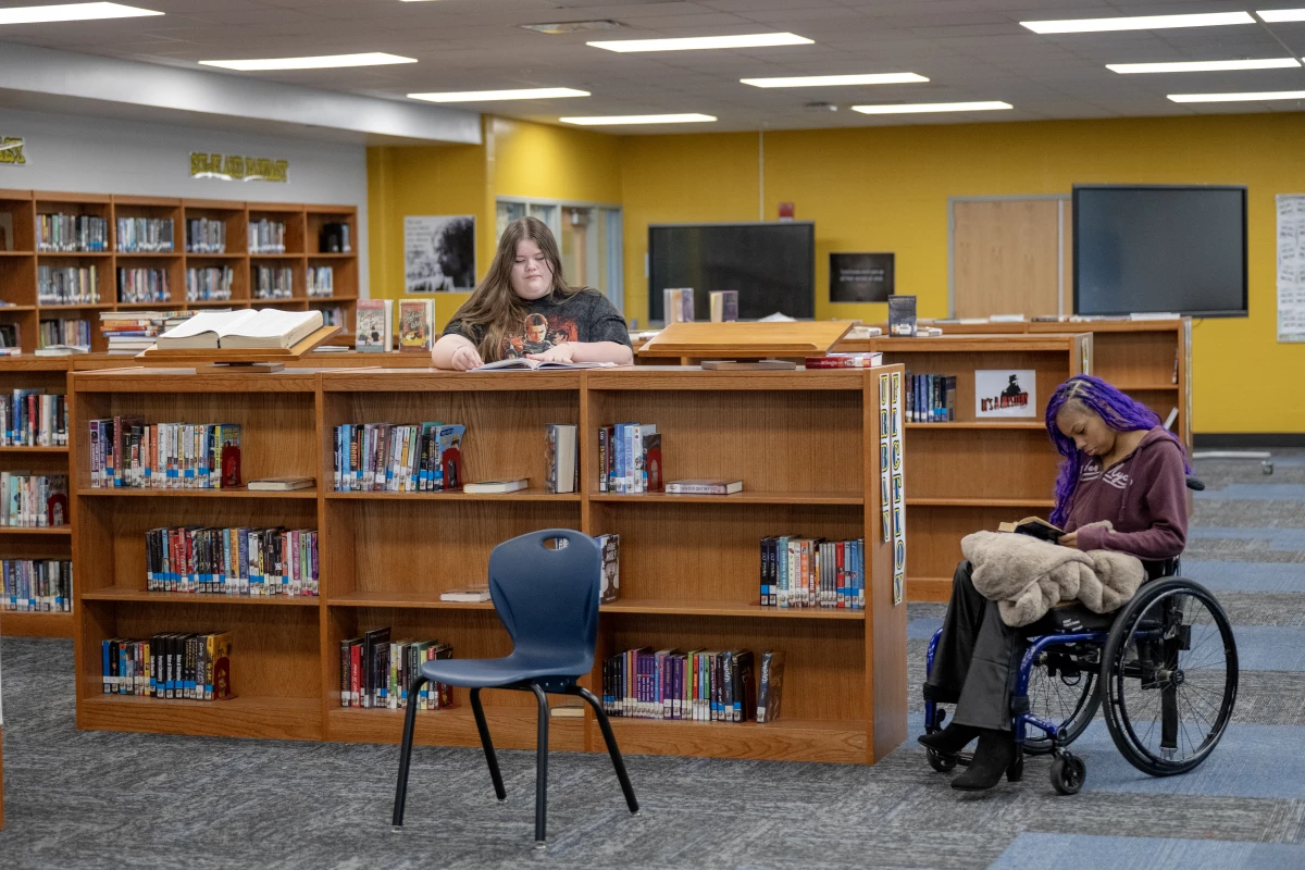 Madelyn Whitt (left) and Quani'e Lanier read in the school library at the Academy @ Shawnee, a magnet middle and high school in Louisville, Kentucky. With cellphones banned at their school, students find other ways to pass time.