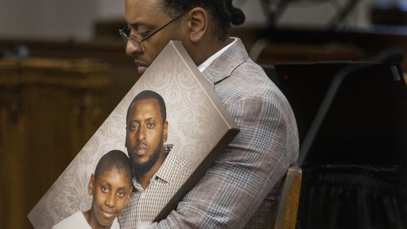 Antonio Mays Sr. holds a portrait of himself and his son.