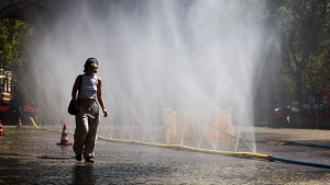 People try to cool off at Rudolfplatz Square during the 'Cooling Cologne' initiative, where chilled groundwater was dispersed through fine mist sprays connected to fire hoses in Cologne, Germany on July 29, 2026.