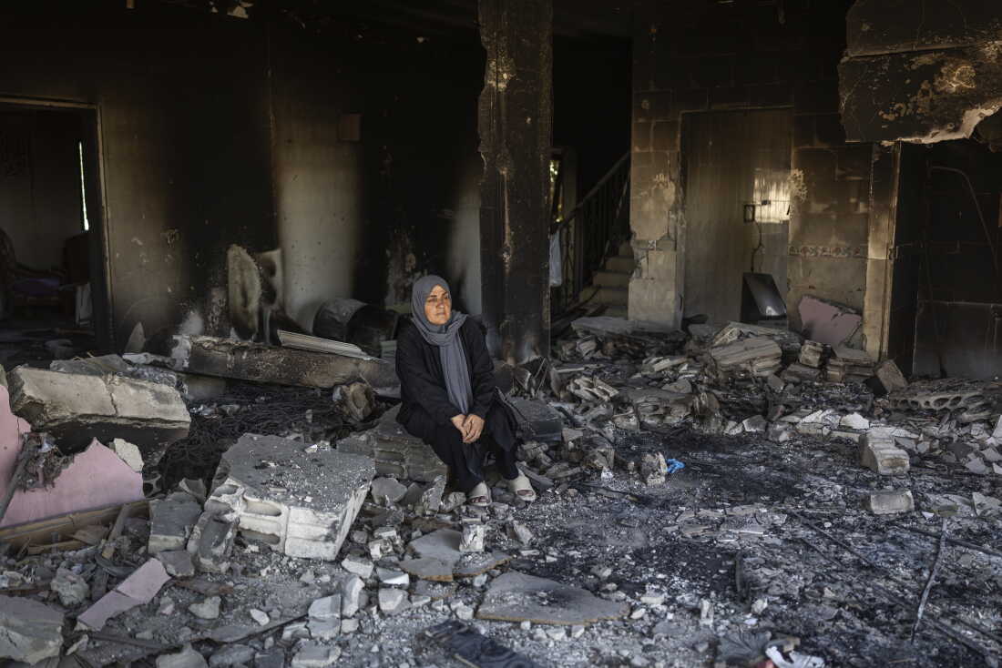 Ihsan Yaghi stands inside her heavily damaged home. She was displaced to Beirut's southern suburbs but returned to her village of Zawtar al-Gharbieh every day. She has six daughters, and her husband is retired.