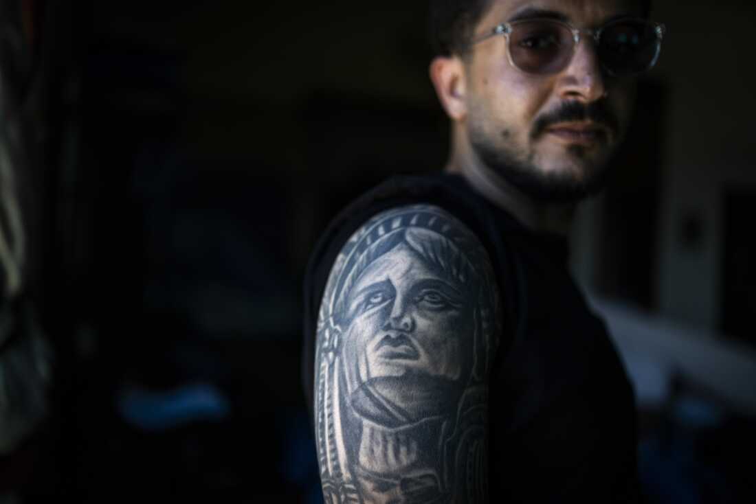 Ali Rida, a member of the Nabatiyeh paramedic team, poses for a portrait. He has a full-sleeve tattoo depicting characters from the movie The Godfather and the Statue of Liberty.