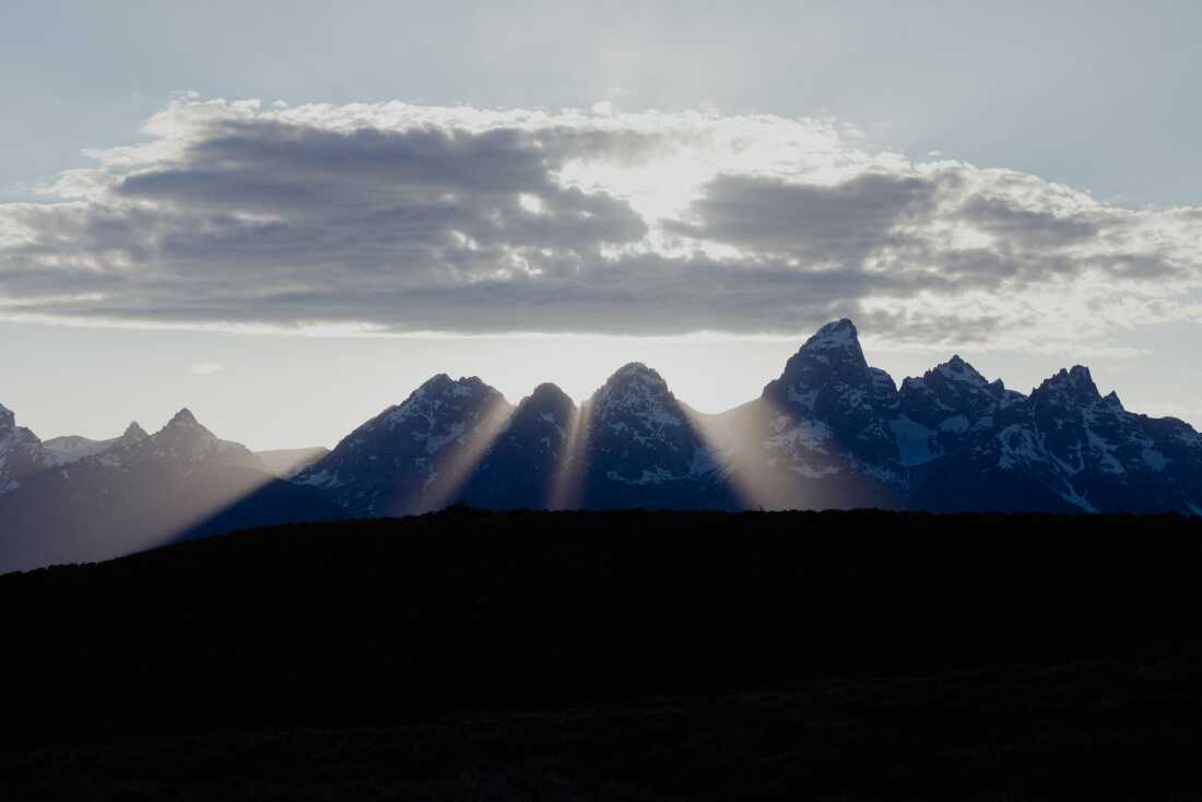 The sun sets behind the Grand Teton Mountains.