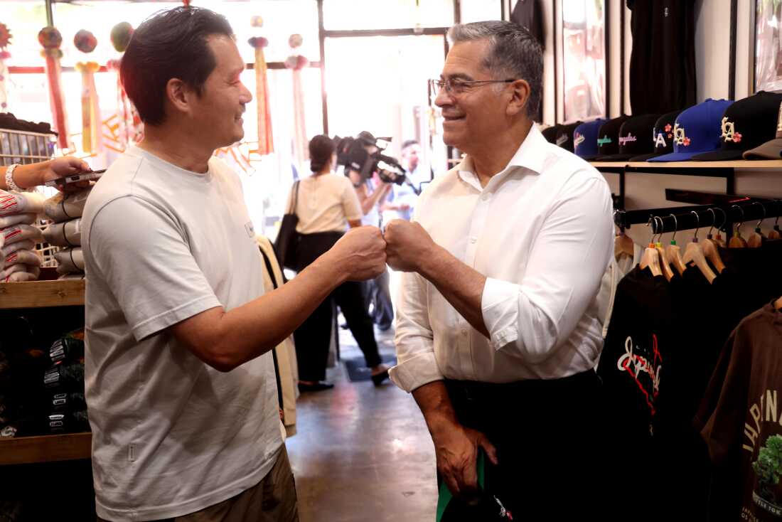 Xavier Becerra is shown fist-bumping a man during a campaign stop.
