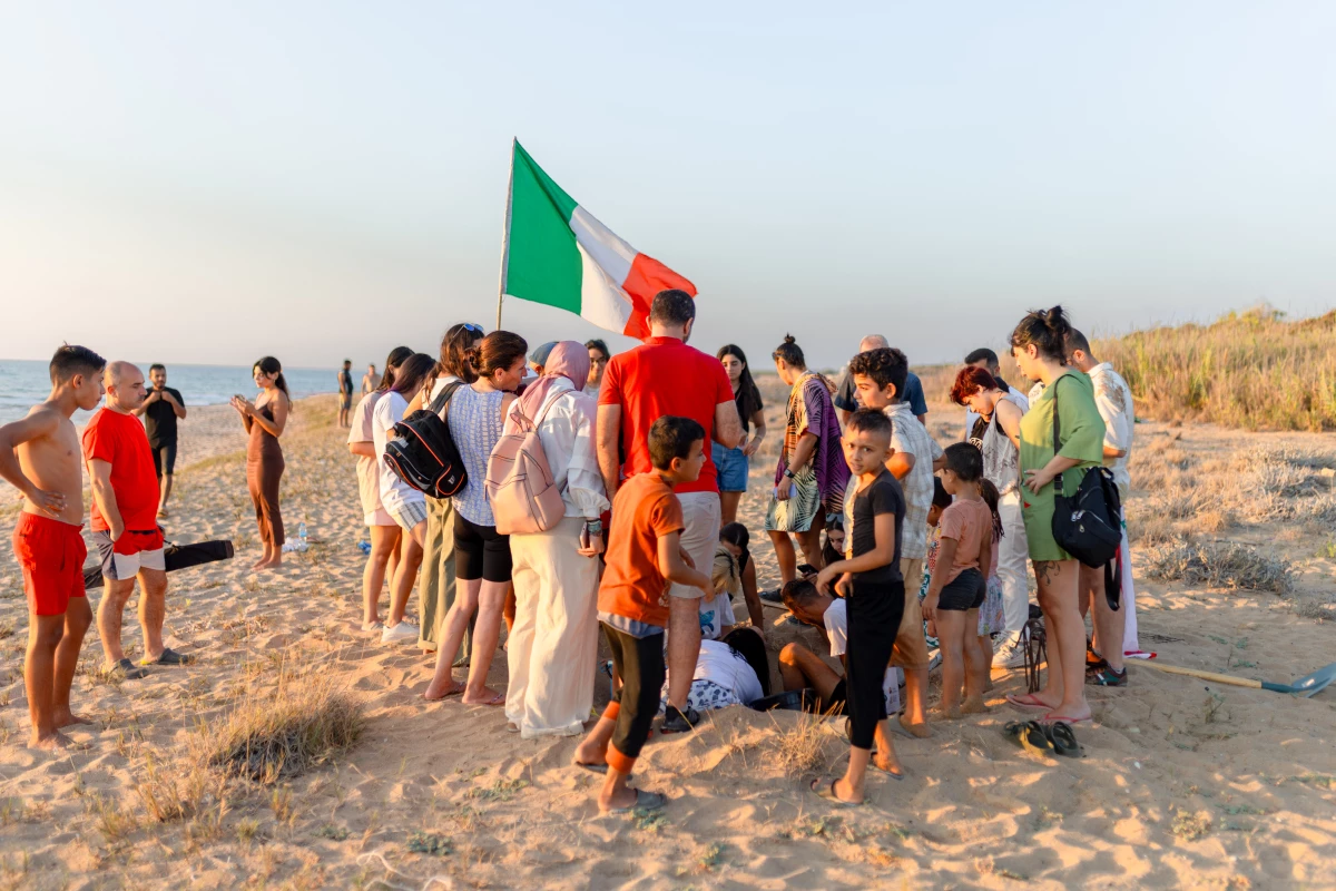 The hatching of endangered sea turtles attracts a small gathering of onlookers and volunteers on Mansouri Beach, in southern Lebanon, on Sept. 8, 2024.