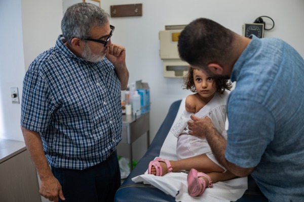 Beirut, Lebanon. August 11, 2025. Six-year-old Kenzi Madhoun from Gaza is examined by Dr. Ghassan Abu Sittah, a British-Palestinian war surgeon, at the American University of Beirut Medical Center. She arrived with her father to begin treatment after being injured in Gaza on Oct. 21, 2023, and is among nearly 35 children brought to Lebanon by the Ghassan Abu Sittah Children’s Fund for medical and psychological support before returning home. Diego Ibarra Sánchez for NPR
