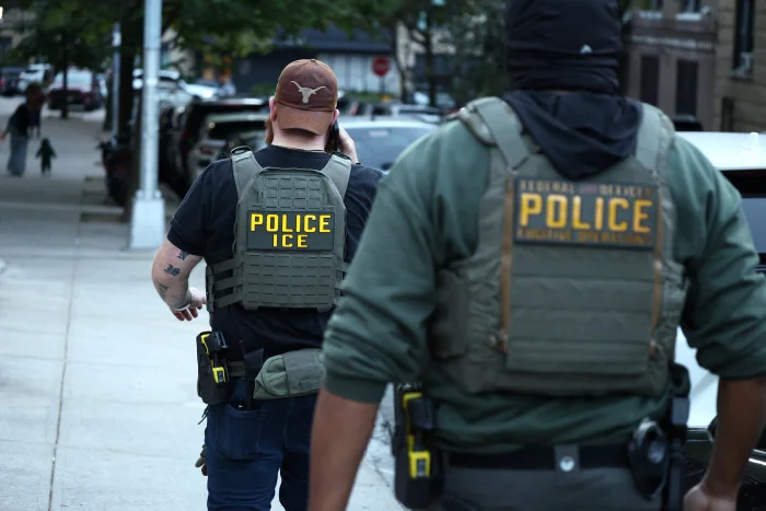 Federal agents walk near the scene where a man was shot by an Immigration and Customs Enforcement officer during an operation in the Bronx borough of New York on Oct. 8, 2026.