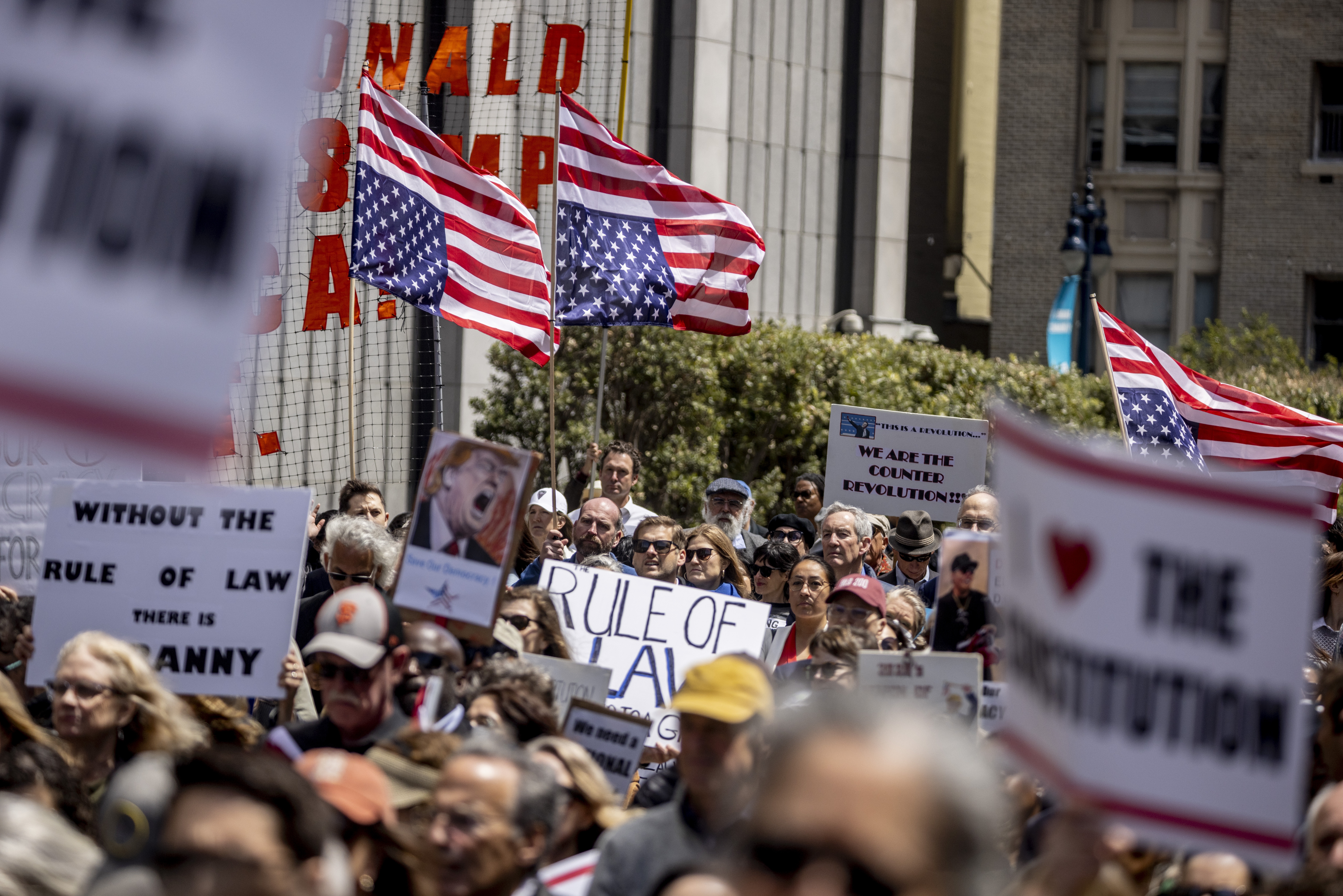 Attendees hold inverted U.S. flags, a sign of distress, during a rally organized by the Bar Association of San Francisco in support of attorneys and law firms targeted by President Donald Trump on May 1.