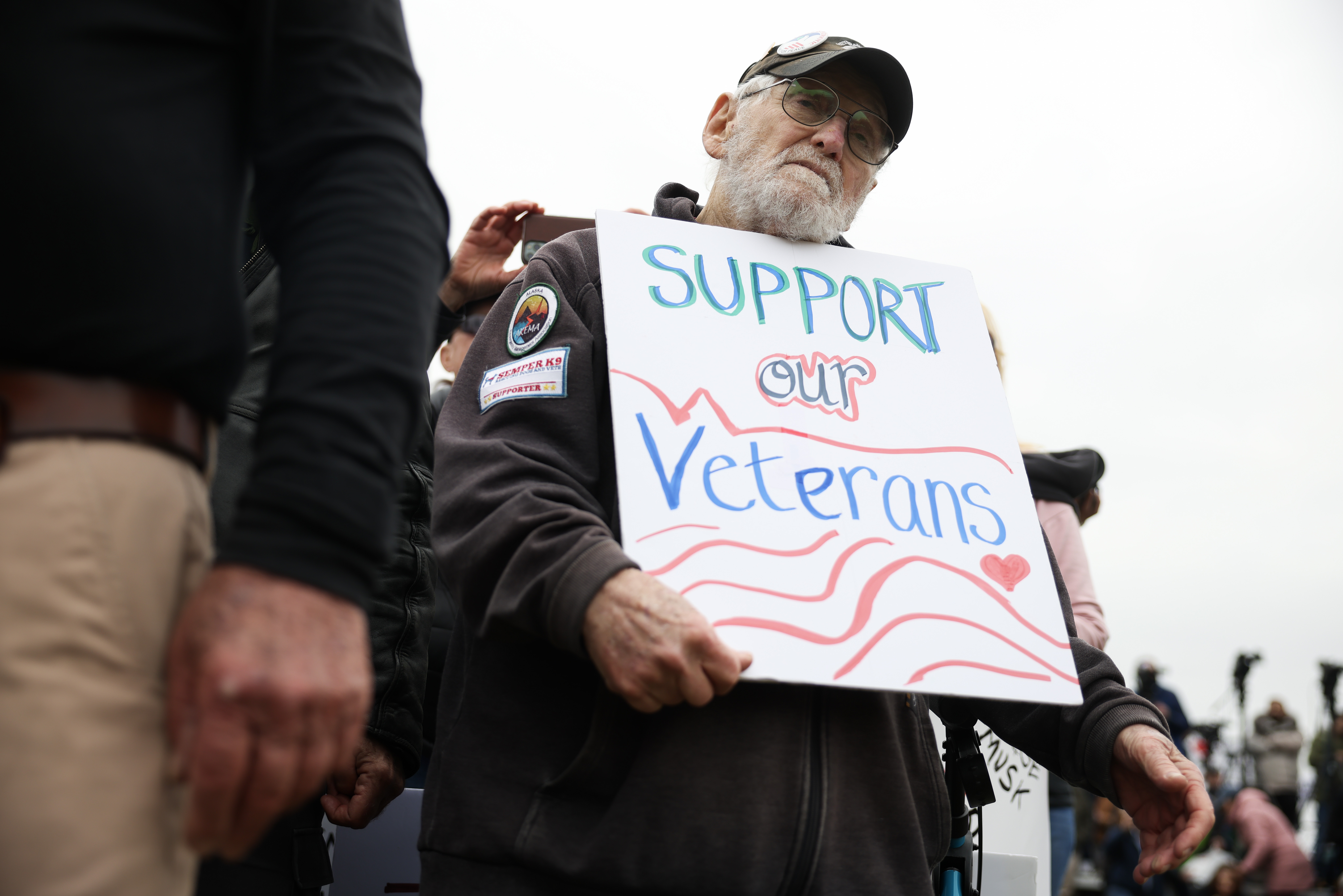 John Spitzberg, 87, holds a "Support our Veterans" sign during a "Veterans March" at the National Mall on March 14, 2025, in Washington, D.C. The 87-year-old veteran was arrested June 13 at the U.S. Capitol while protesting the U.S. Army