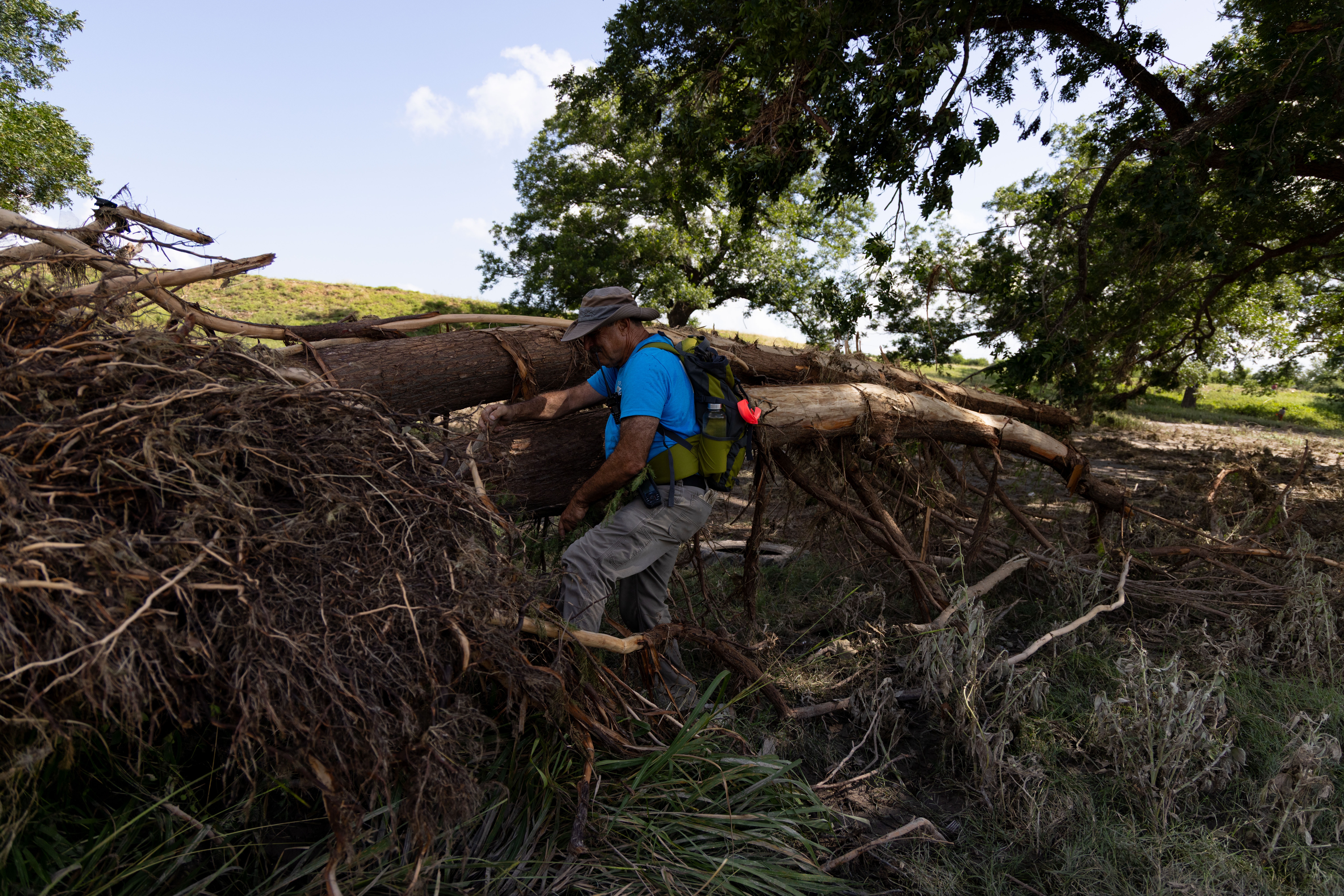 Neil Summer, with the Matagorda Volunteer Fire Department, leads a search group made up of volunteers on the banks of the Guadalupe River near Center Point, Texas on Monday. The group was performing a "hasty search," which is where they quickly clear an area and move on in hopes of more quickly finding survivors.