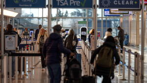 FILE - Travelers walk through a TSA security checkpoint at Reagan National Airport in Washington, March 24, 2026.