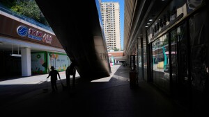 A worker collects trash in a partially shuttered Evergrande commercial complex, on the day Hong Kong Stock Exchange delisted the Chinese property developer China Evergrande, in Beijing, China, Aug. 25, 2025.