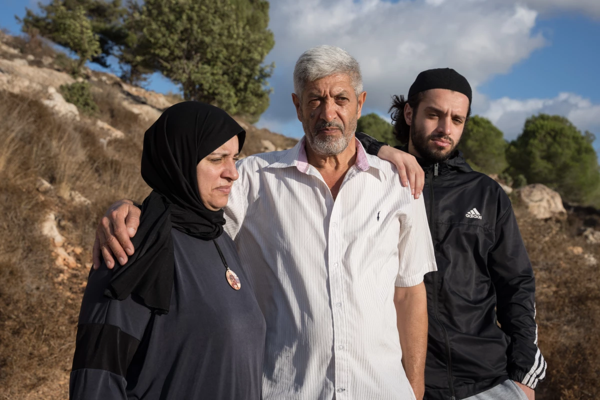 The parents and brother of Palestinian-American Mohammad Khdour stand in the outskirts of Biddu, the West Bank, on Sept. 19. Mohhamad, 17, was shot while he was driving in the hills not far from their home in February.