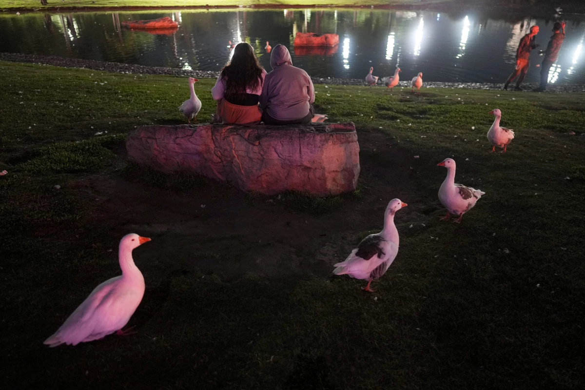 People sit outside the planetarium to watch the total lunar eclipse on Friday in Buenos Aires, Argentina.