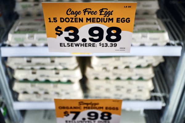 A sign on a refrigerated display case of eggs in a grocery store in Hailey, Idaho, advertises the price of $3.98 for 1.5 dozen cage-free medium eggs, compared to $13.39 elsewhere.