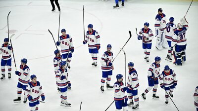 USA's players raise their sticks after winning the men's play-off semi-final ice hockey match between USA and Slovakia at the Milano Santagiulia Ice Hockey Arena during the Milano Cortina 2026 Winter Olympic Games in Milan, on February 20, 2026. USA won 6-2.