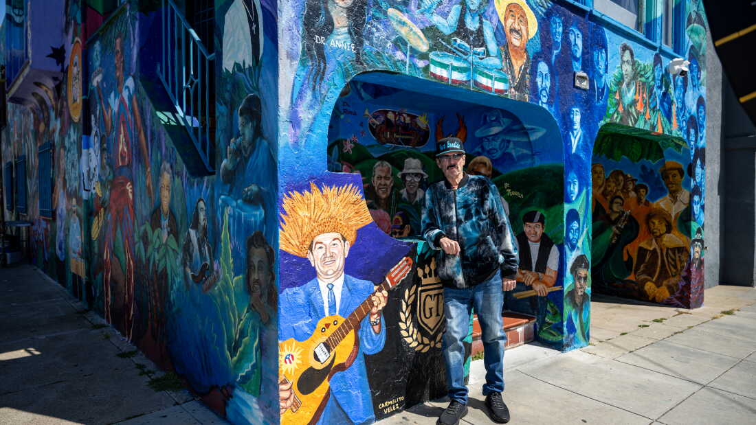 Richard Segovia stands in front of his house on 25th and York streets, known as the Latin Rock House, in San Francisco on April 7, 2026. The home is covered in a large mural honoring dozens of musicians tied to the Mission District’s Latin rock scene, which Segovia has helped preserve for decades.