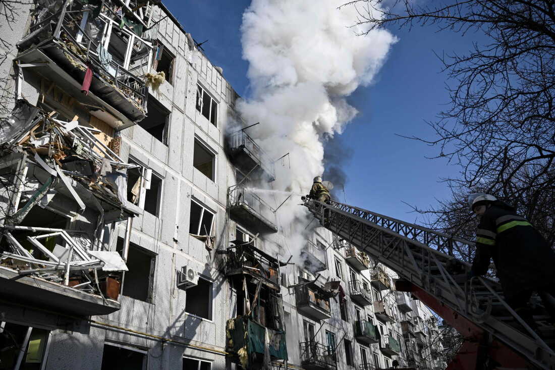 Firefighters climbing on a firefighting crane work to put out a fire at a bombed multistory building in Chuhuiv, Ukraine, on February 24, 2022.