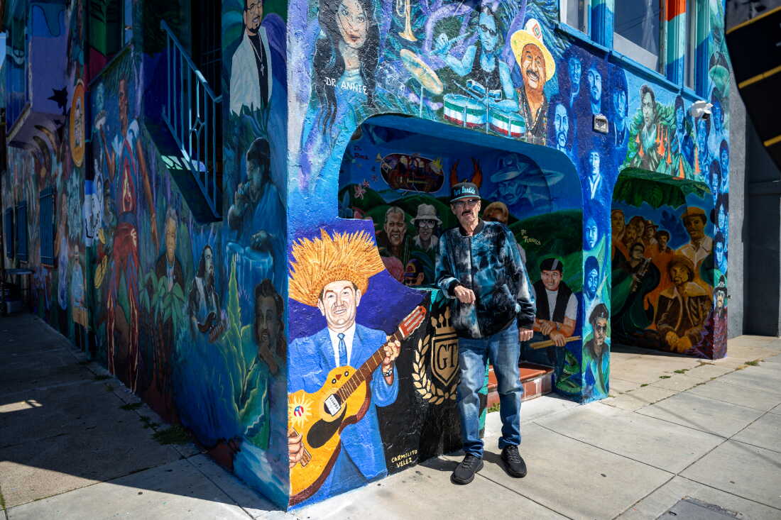 Richard Segovia stands in front of his house on 25th and York streets, known as the Latin Rock House, in San Francisco on April 7, 2026. The home is covered in a large mural honoring dozens of musicians tied to the Mission District’s Latin rock scene, which Segovia has helped preserve for decades.