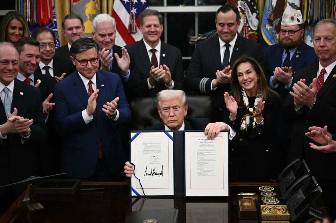 President Donald Trump shows the signed bill package to re-open the federal government in the Oval Office of the White House in Washington, DC, on November 12, 2025.