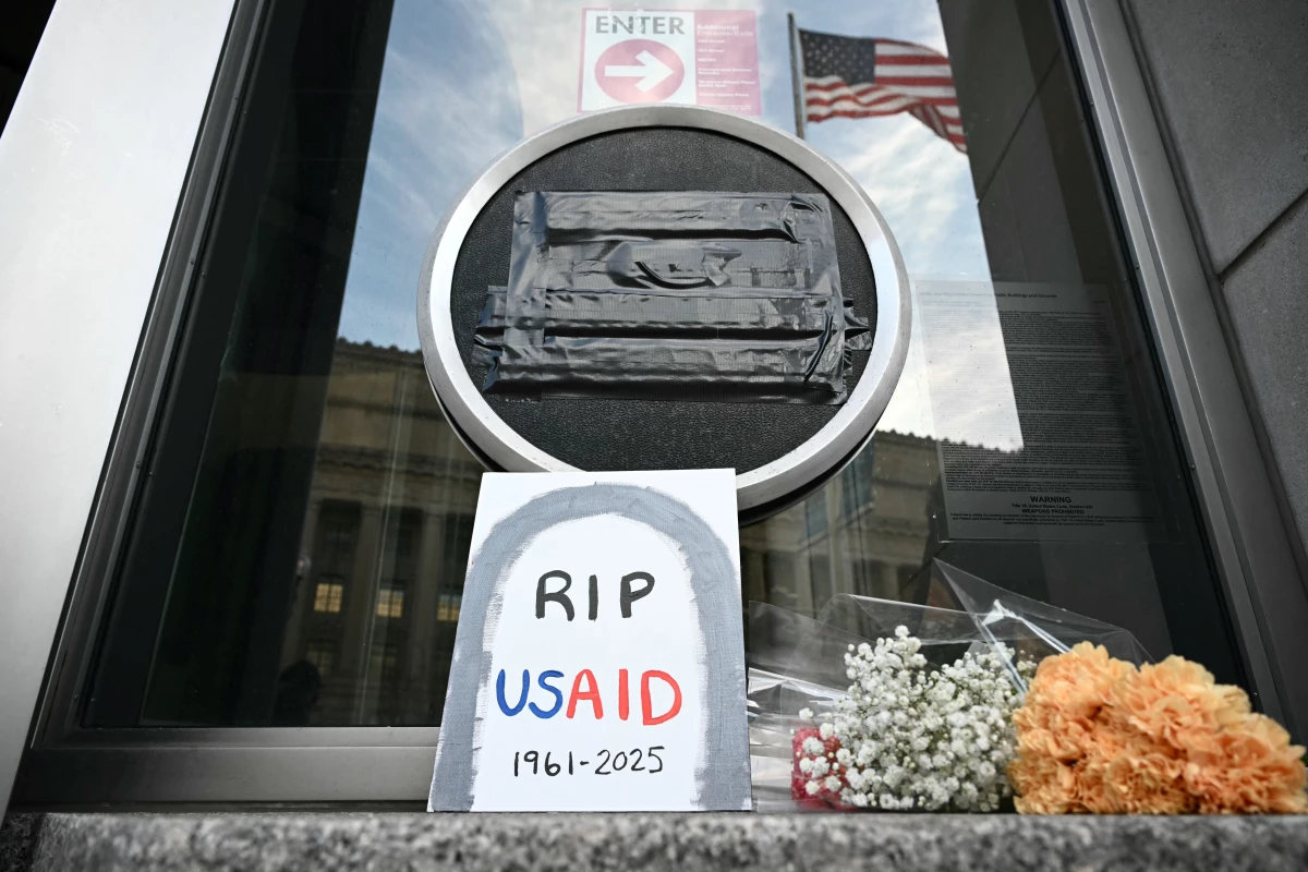 Tributes are placed beneath the covered seal of the United States Agency for International Development (USAID) at their headquarters in Washington, D.C., on February 7, the day that President Donald Trump called for the agency to be shuttered. July 1 marks the agency's official demise.