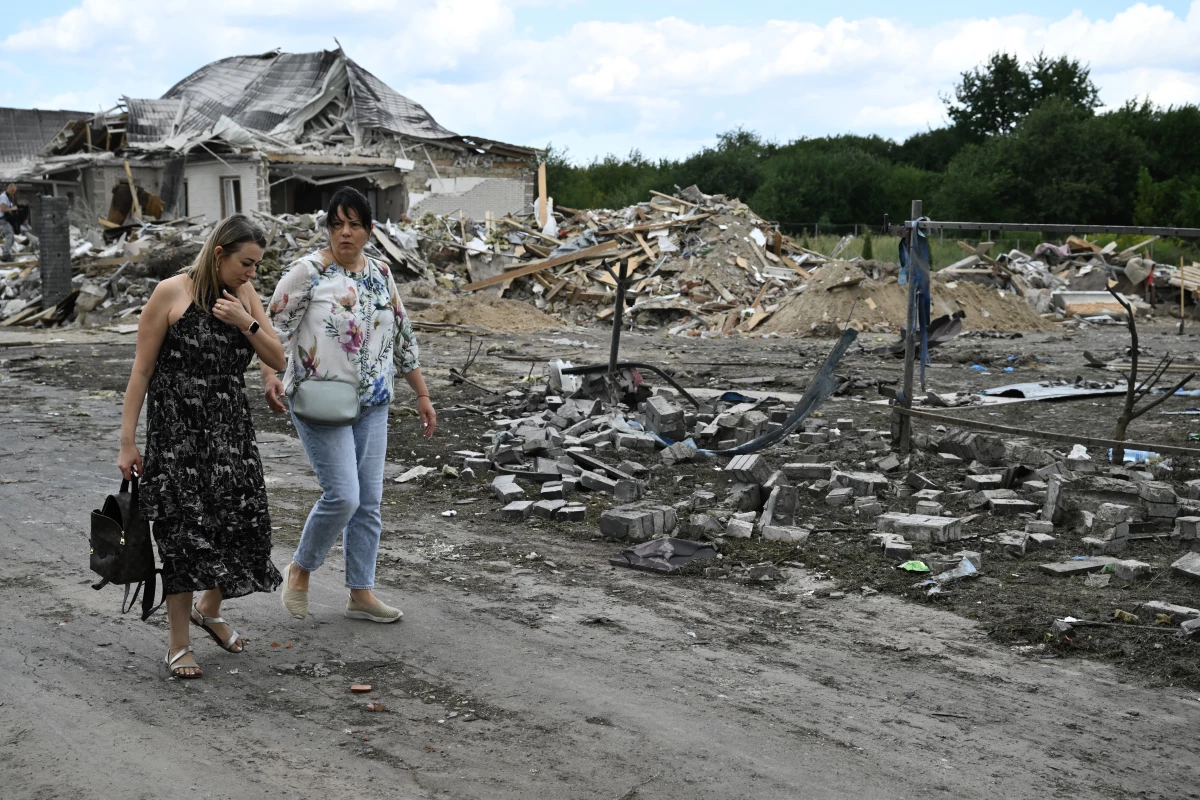 Local residents walk past a residential house, heavily damaged following a Russian missile strike on Sunday, in a village in the Brovary district, Kyiv region, amid the Russian invasion of Ukraine. Fragments of a missile fell on residential buildings in Brovary district, near Kyiv, the State Emergency Service of Ukraine said on Telegram.